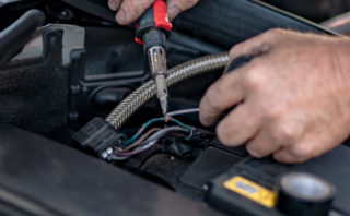 Mechanic fixing wiring in a European car.