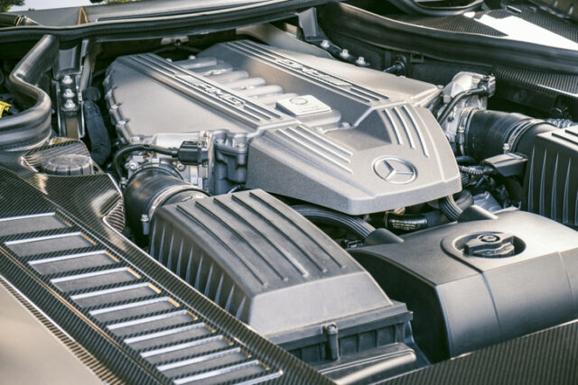 A close-up view of a Mercedes-Benz W205 C-Class engine under the hood, showing detailed components and parts of the engine.