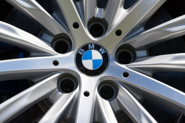 Close-up of a silver BMW car wheel rim with the blue, white, and black BMW logo in the center—one of those hidden gems that true automotive enthusiasts appreciate.