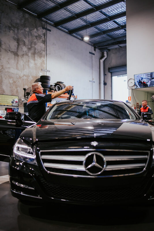 Technician checking a European car with diagnostic equipment at Accelerate Automotive.